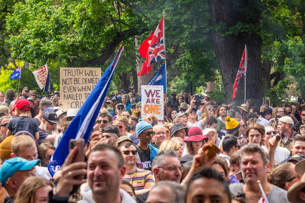 a large crowd of people holding flags and signs