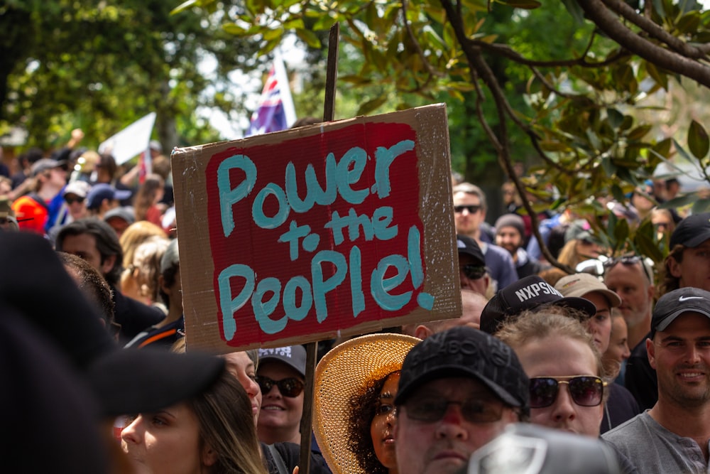 a crowd of people standing around each other holding signs