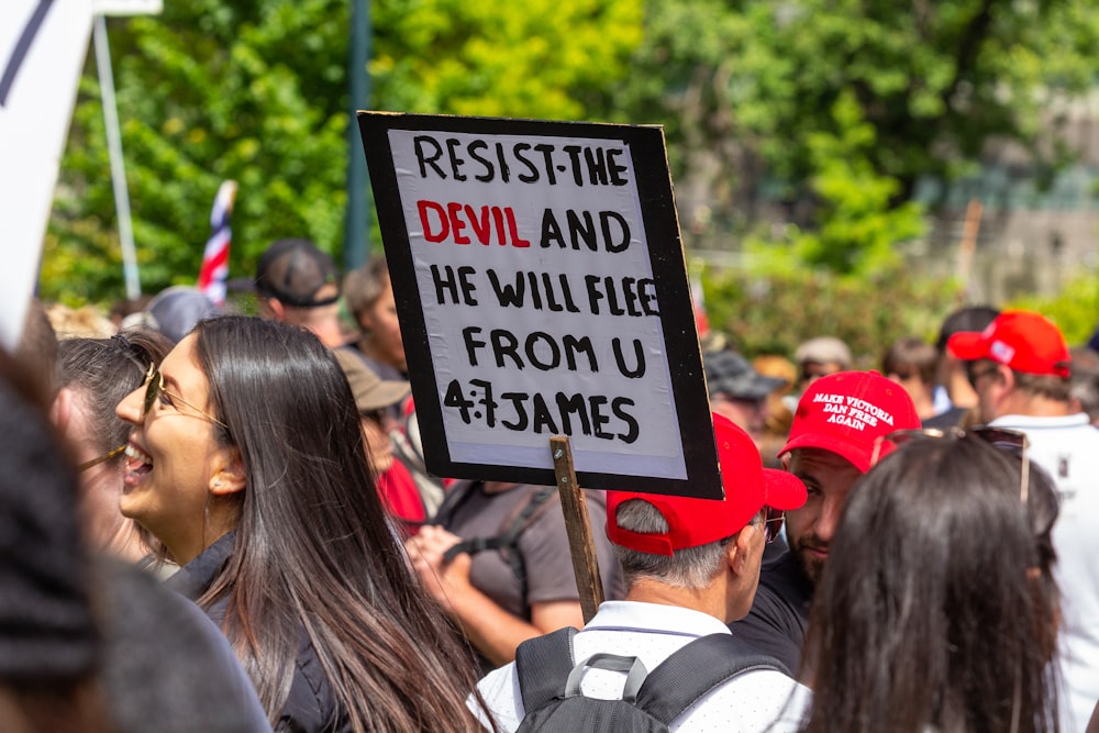 a group of people standing around each other holding signs