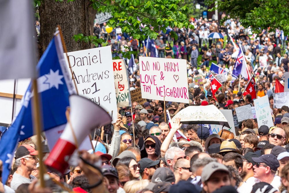 a large crowd of people holding signs and flags