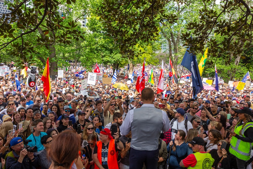 a large crowd of people standing around each other