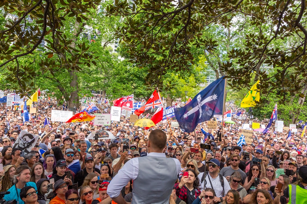 a large crowd of people holding flags and signs