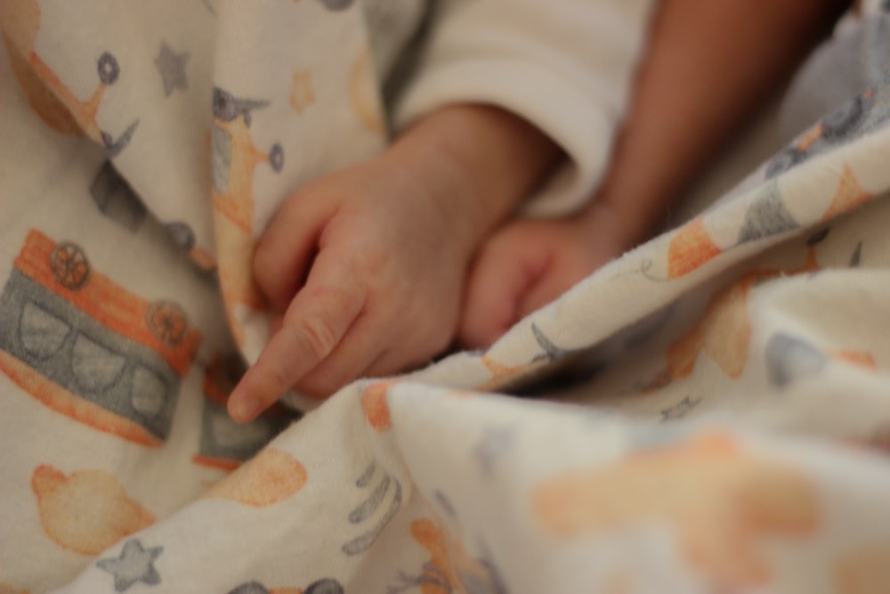 a close up of a person's hand on a blanket