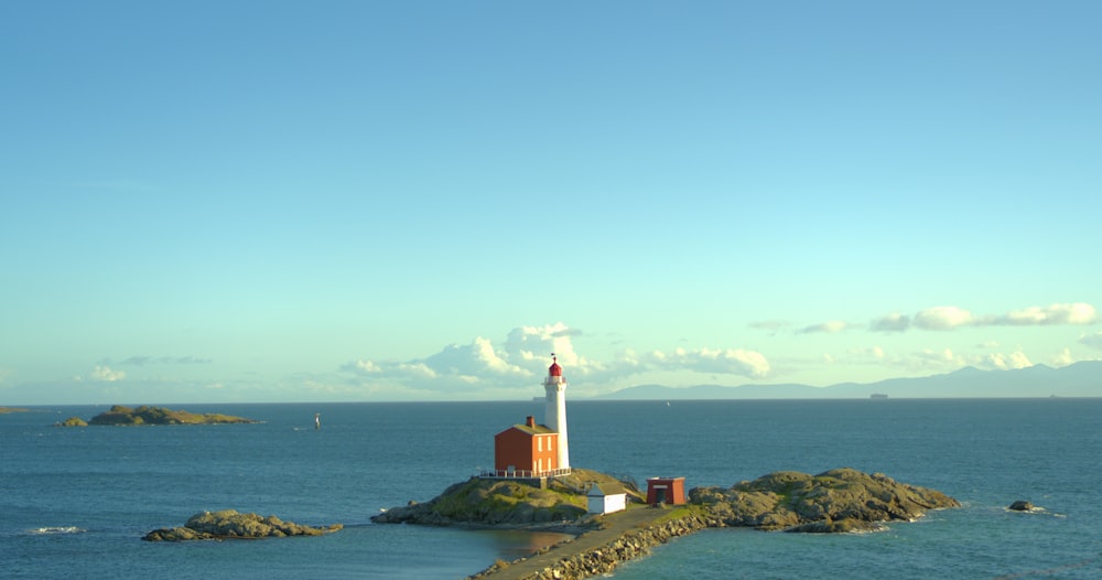 a lighthouse on a small island in the middle of the ocean