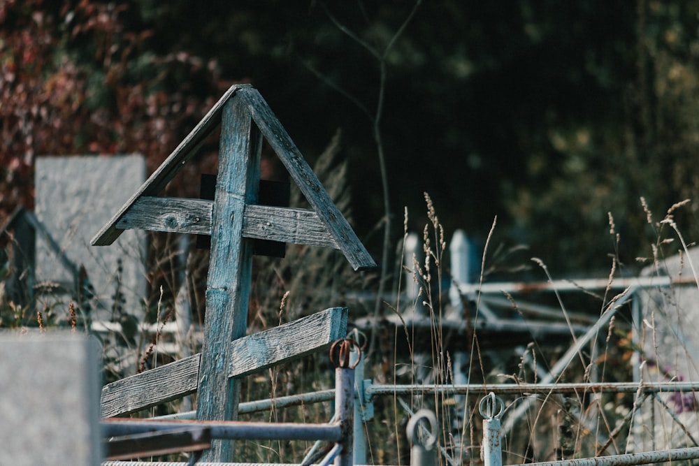 a wooden cross sitting on top of a wooden fence