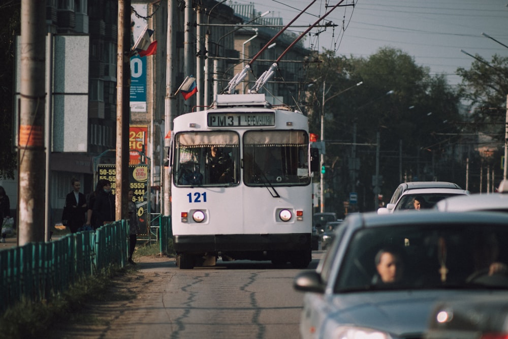 a white bus driving down a street next to traffic