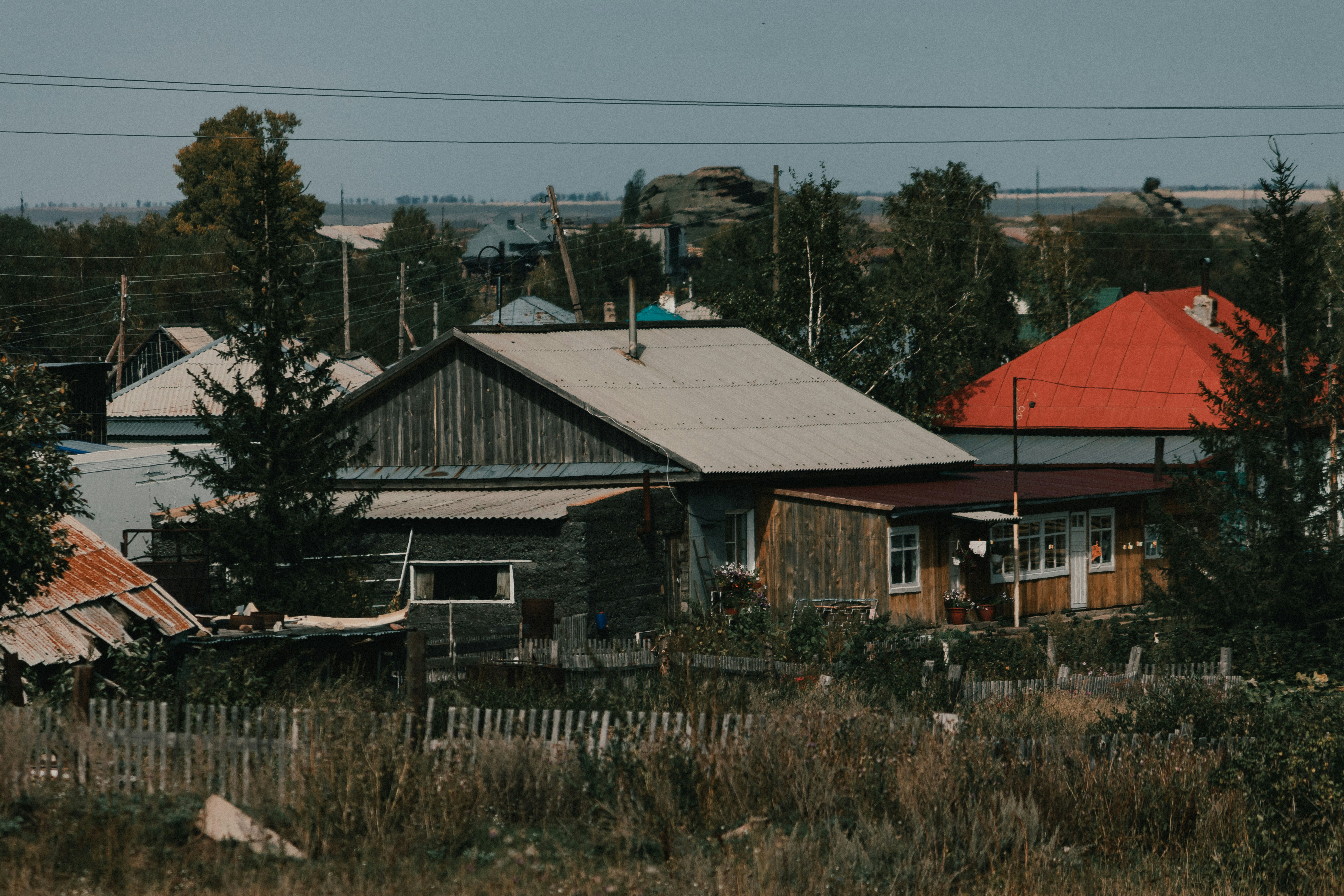 a house with a red roof in the middle of a field