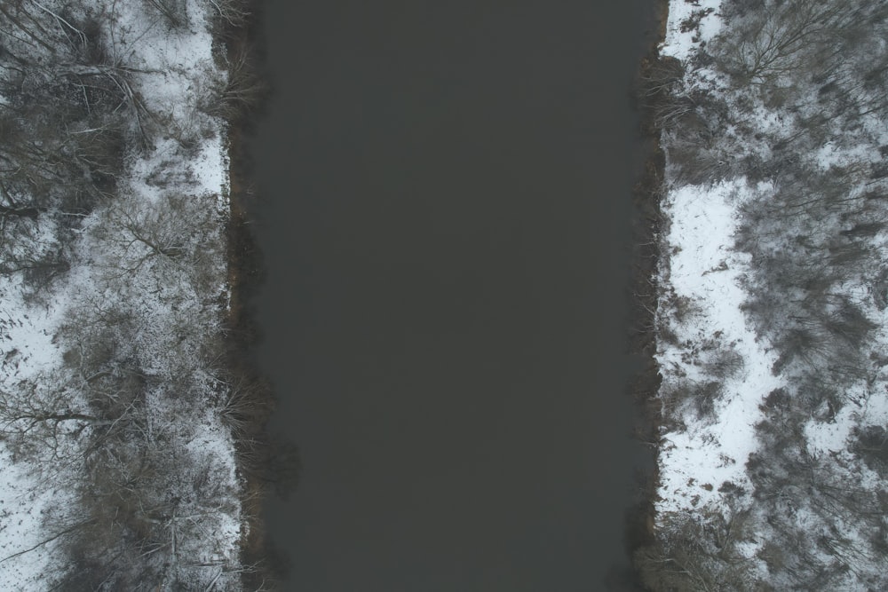 an aerial view of a body of water surrounded by snow