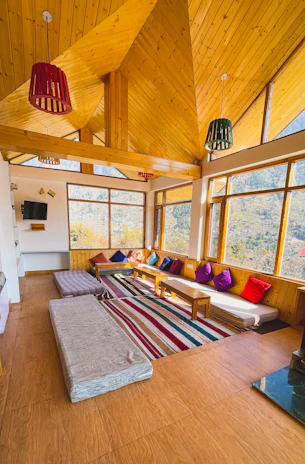 Family room with spacious layout, cozy seating, and large windows framing the Himalayan landscape.