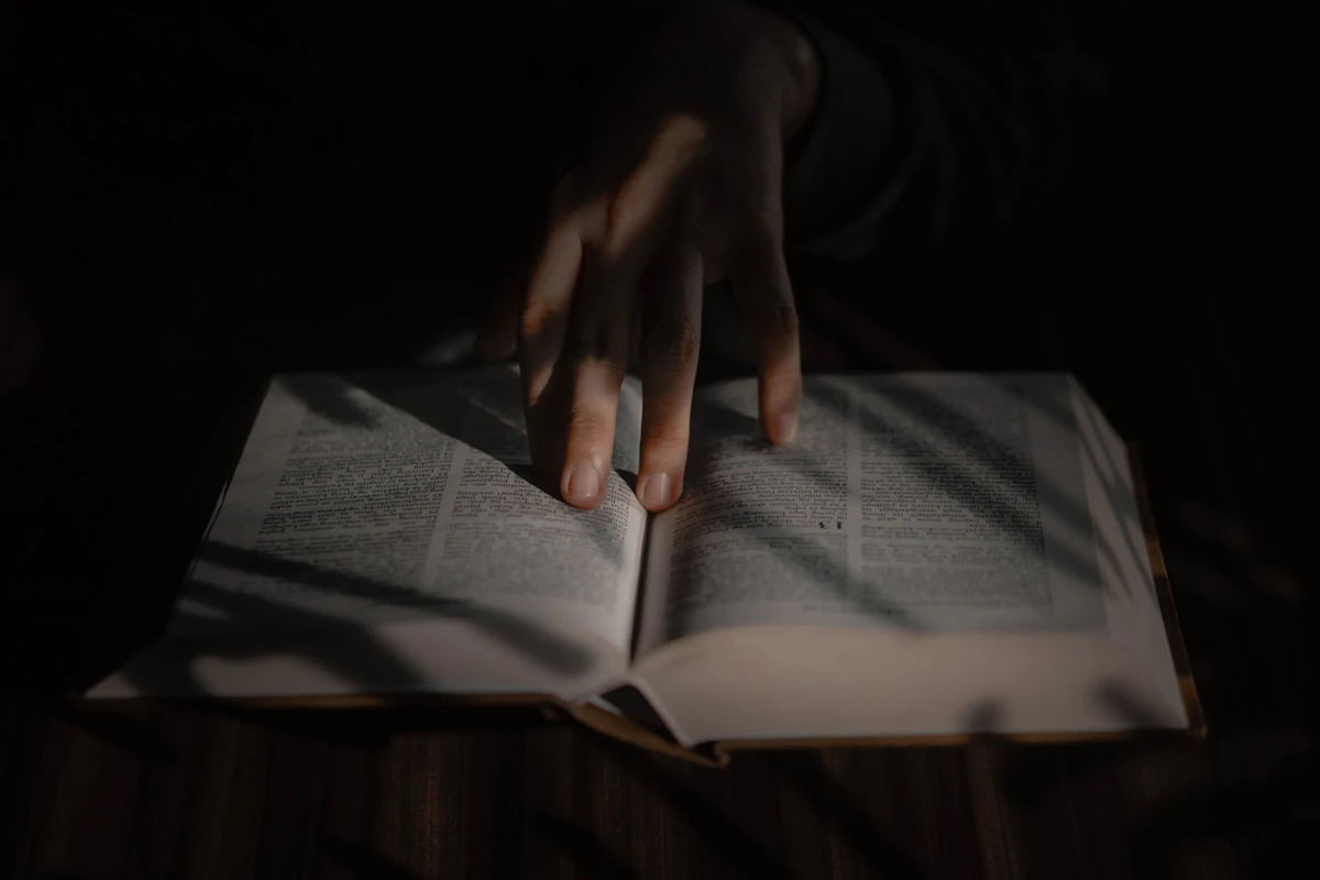 Tangan di atas buku terbuka