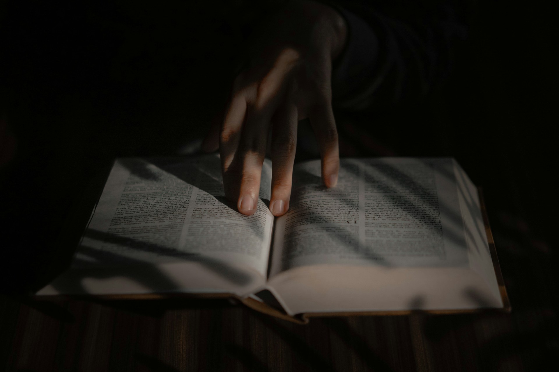 a person's hand on top of an open book