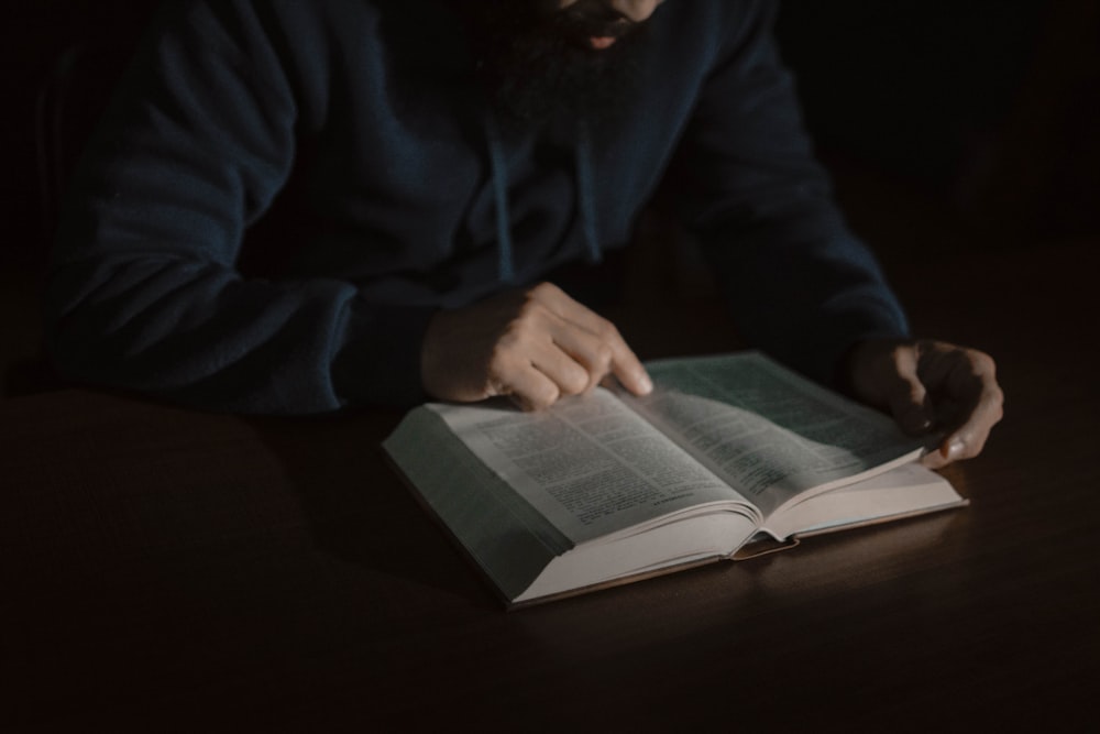 a man sitting at a table reading a book