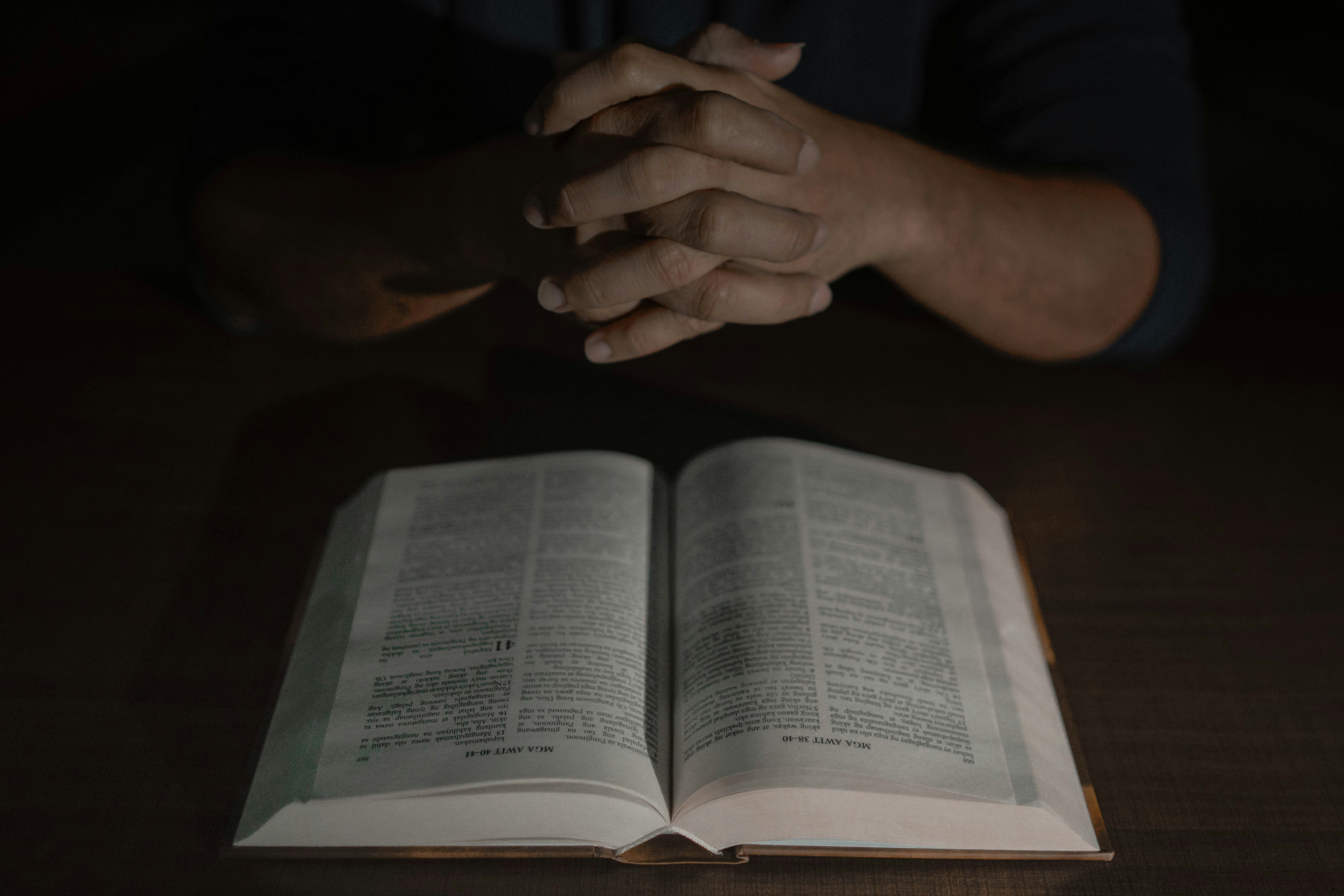 a person holding their hands over an open book