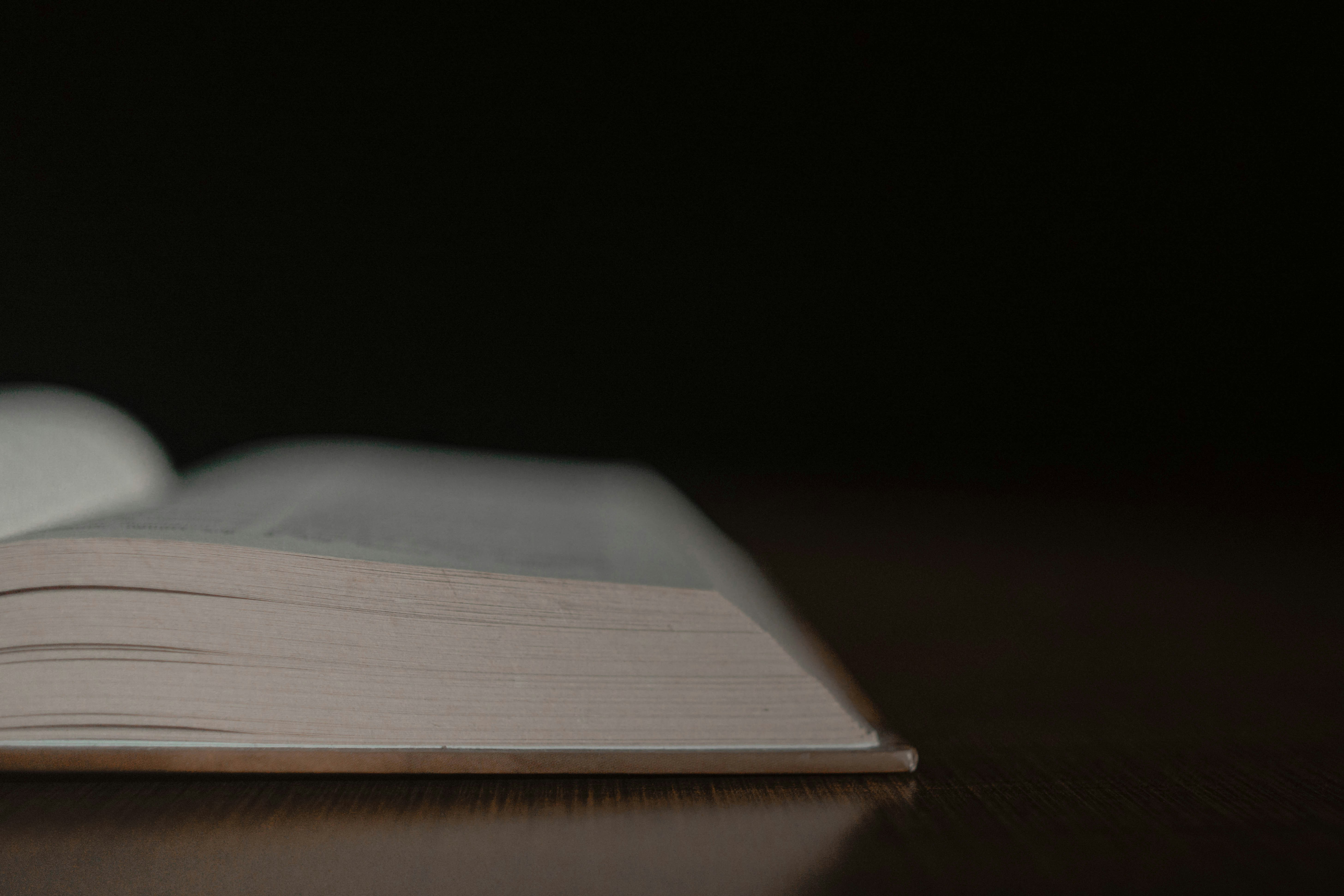 an open book sitting on top of a wooden table, 