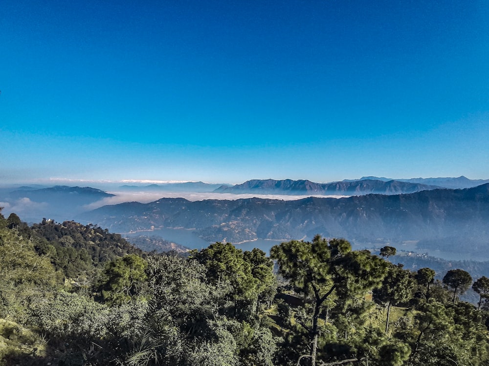 a view of a mountain range with trees and mountains in the background