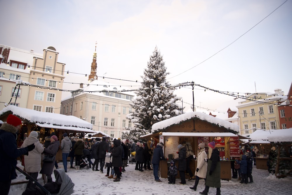 a group of people standing around a christmas tree