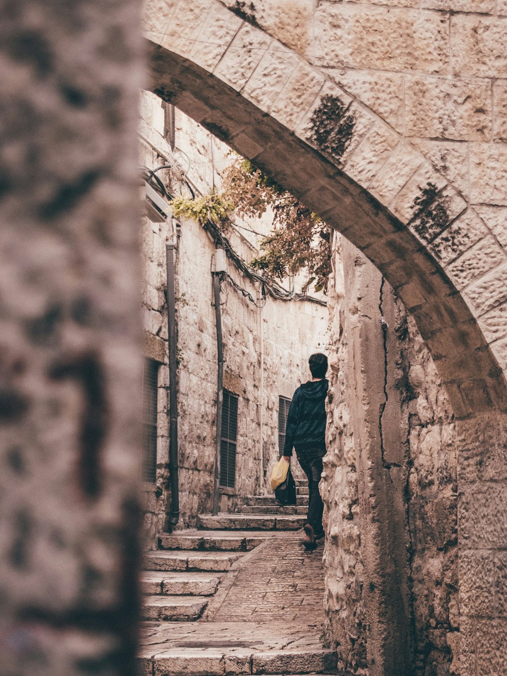 a man is walking down a narrow alley way