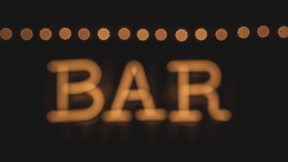 a close up of a bar sign lit up at night