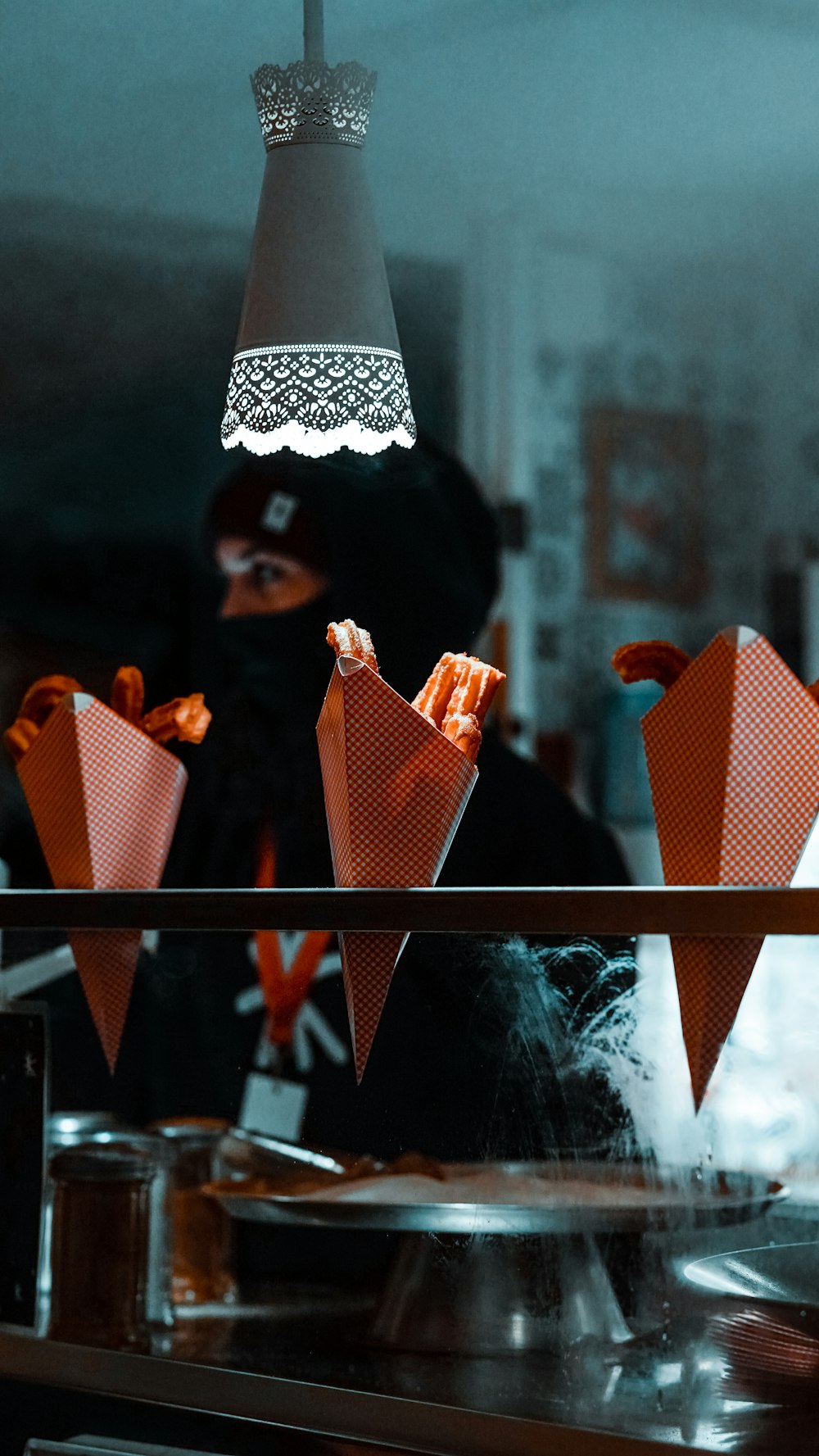 a person in a black mask behind a counter