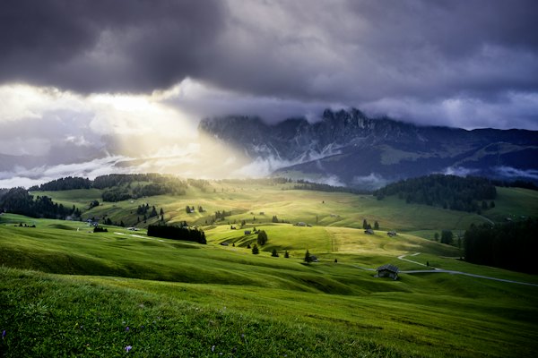 A lush green hillside under a cloudy sky — Dolomites, Italy