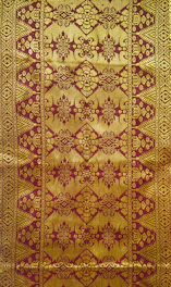 A traditional Javanese batik pattern with maroon and gold colors.