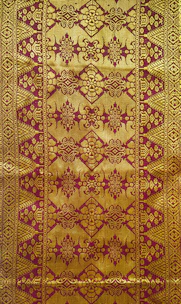 A traditional Javanese batik pattern with maroon and gold colors.