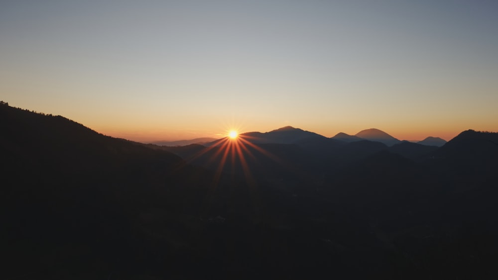 El sol se está poniendo sobre una cadena montañosa