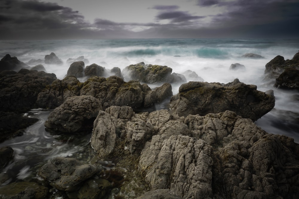 a black and white photo of rocks and water