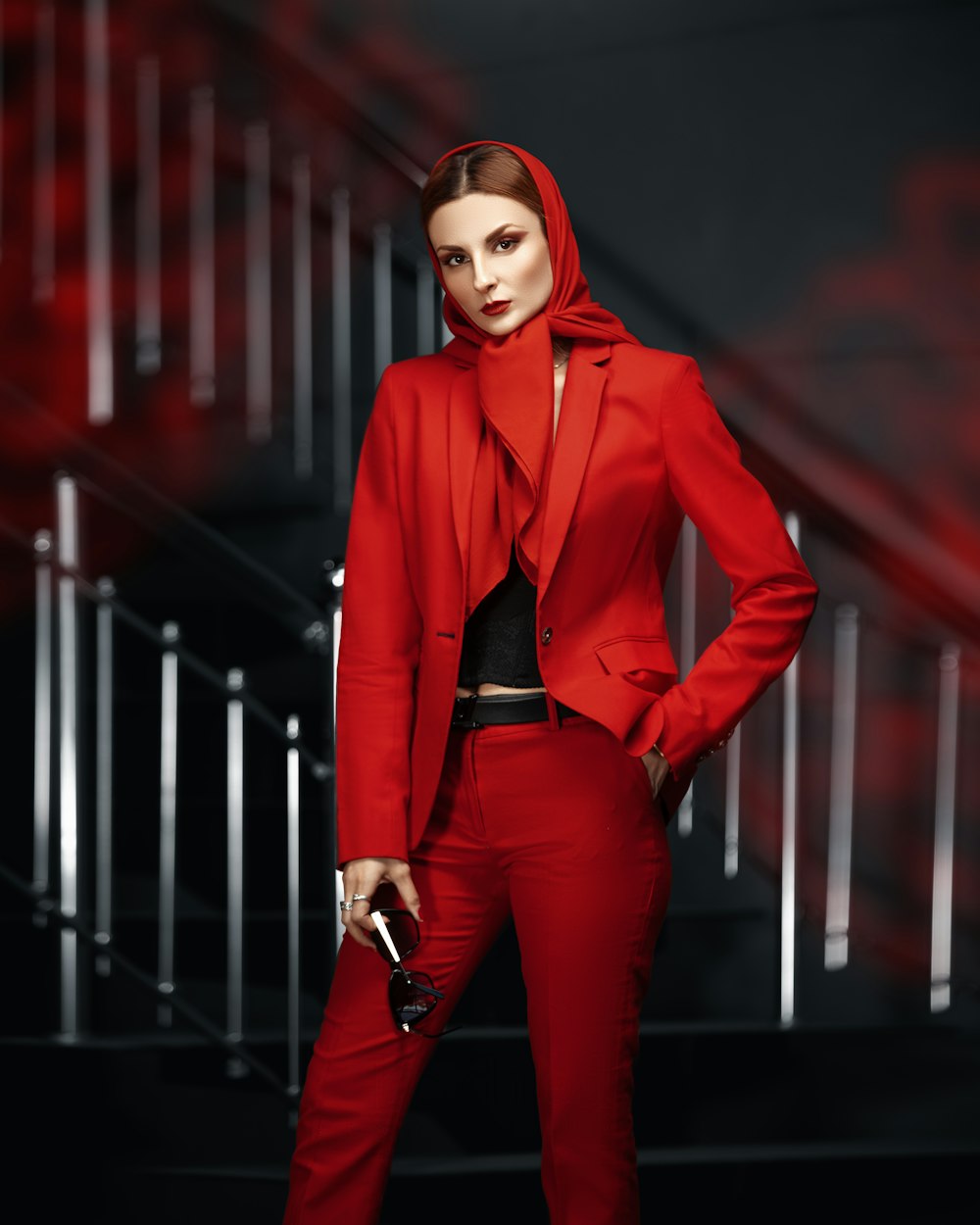 a woman in a red suit with a gun