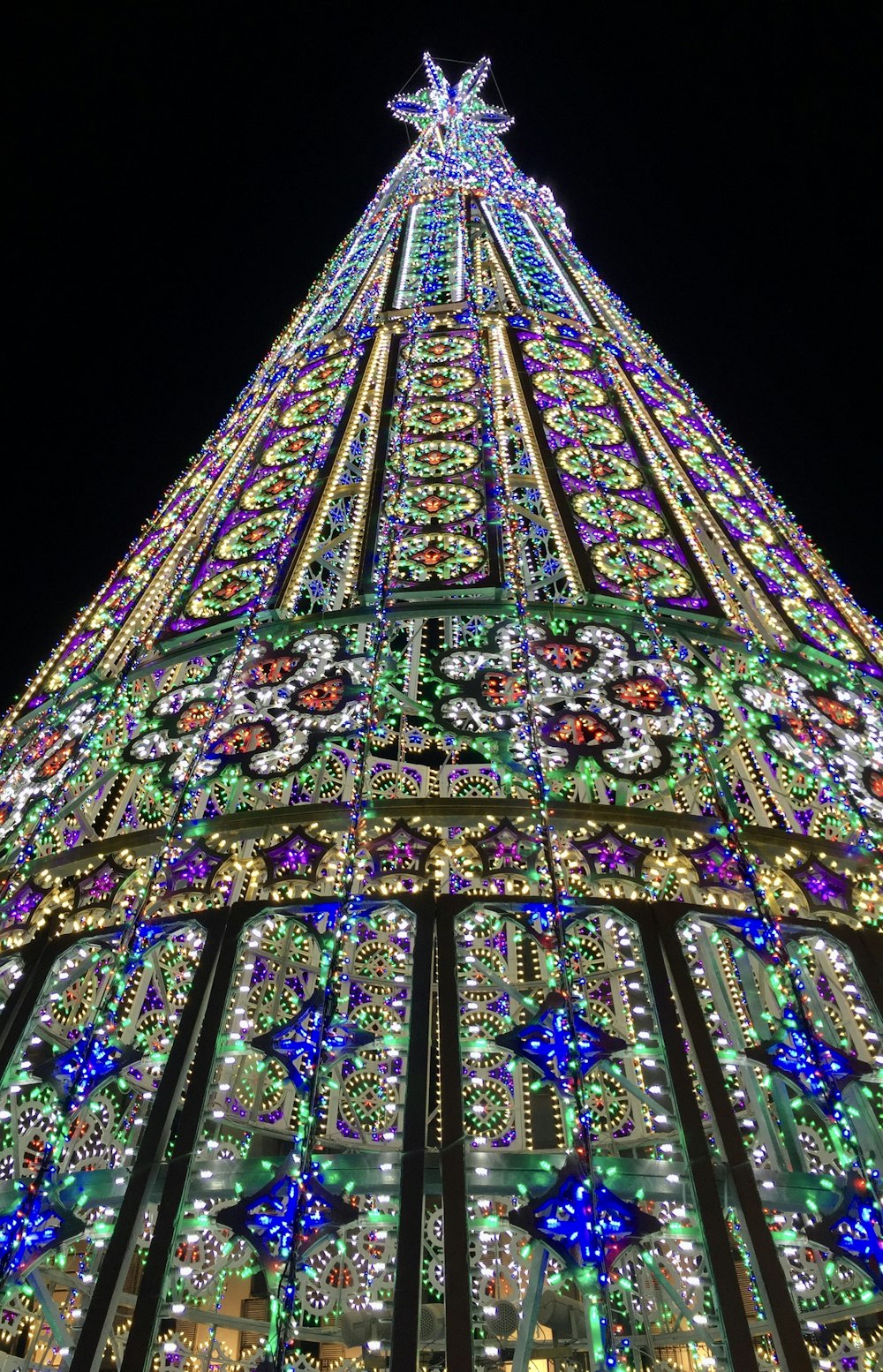 a very tall christmas tree with lights on it