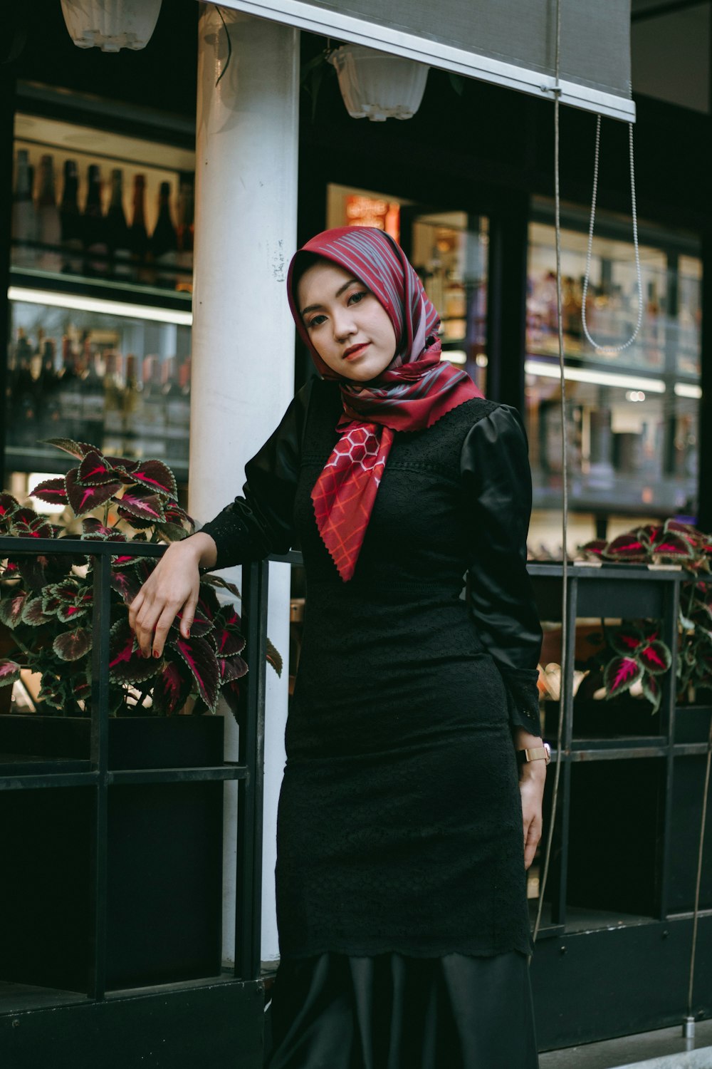 a woman wearing a hijab standing in front of a store