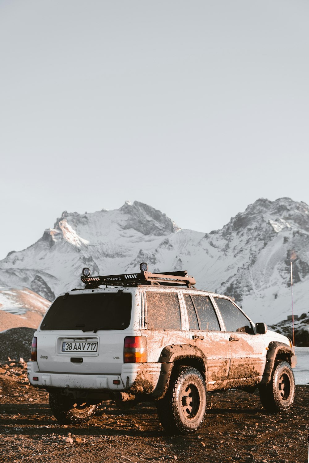 a white suv parked on top of a dirt field