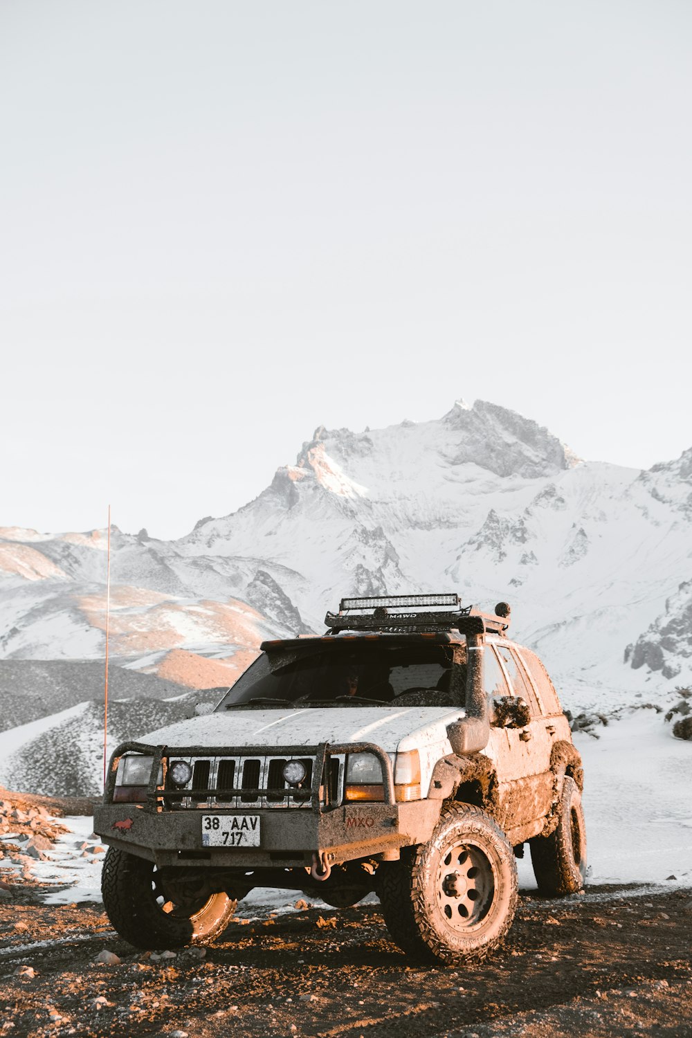 a jeep is parked in front of a mountain