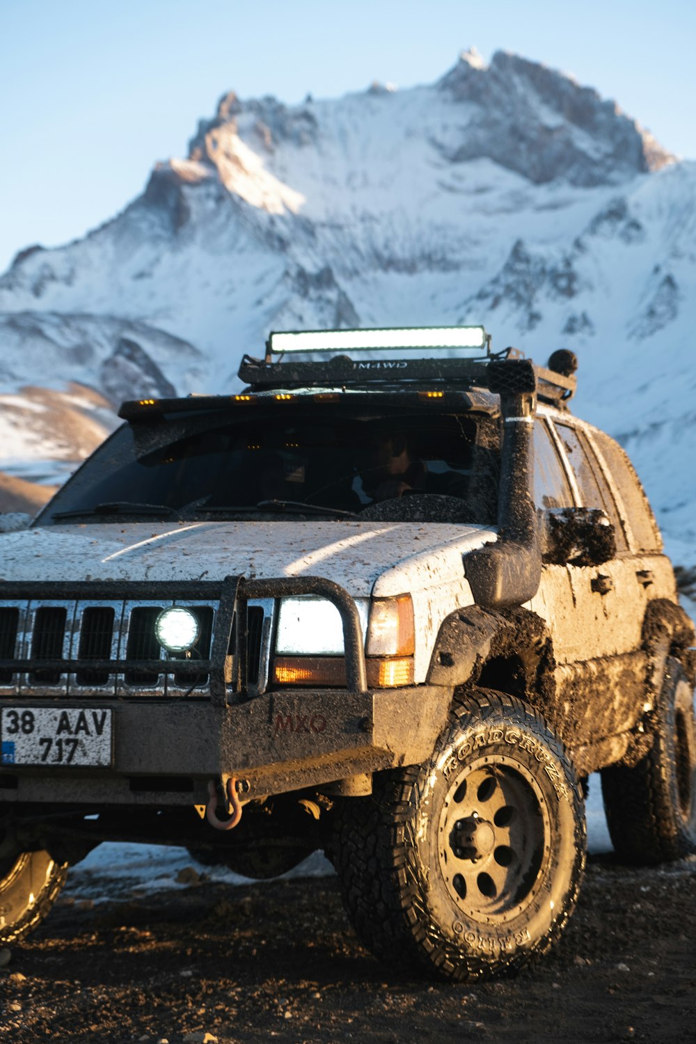 a truck parked in front of a snow covered mountain