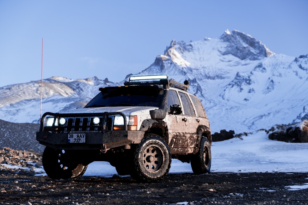 Ein Fahrzeug, das vor einem verschneiten Berg geparkt ist