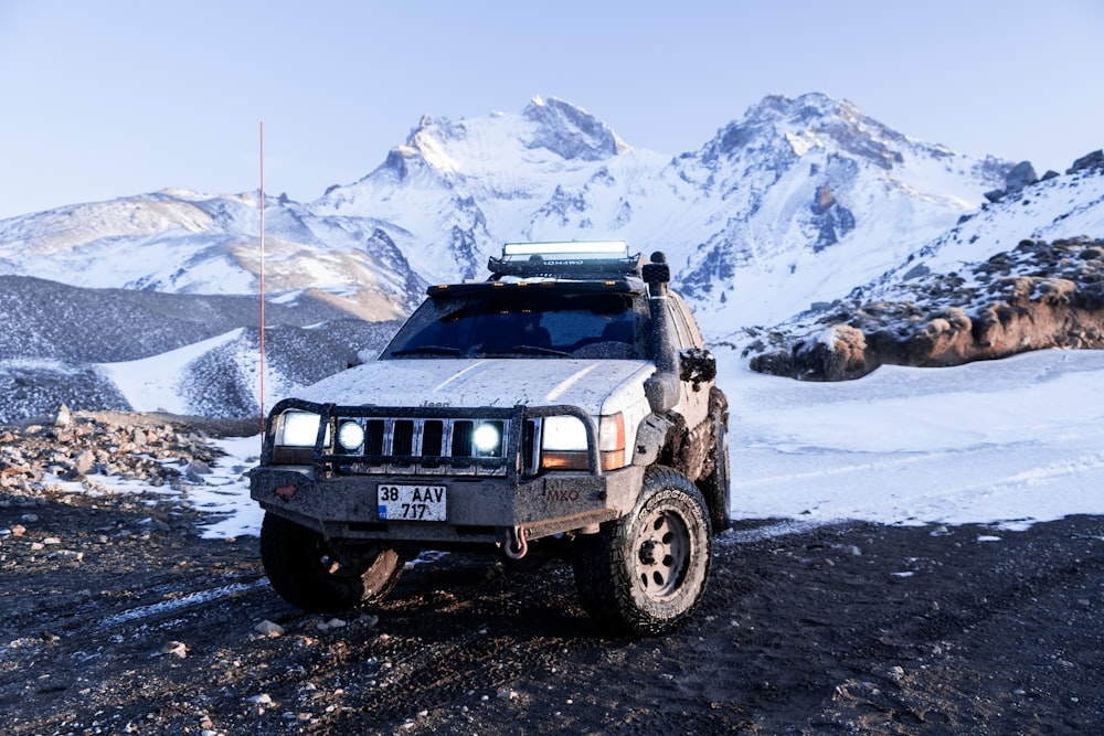 a jeep is parked on the side of a snowy mountain