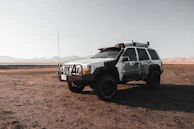 A rugged SUV with all-terrain tires displayed on the lot, perfect for family trips.