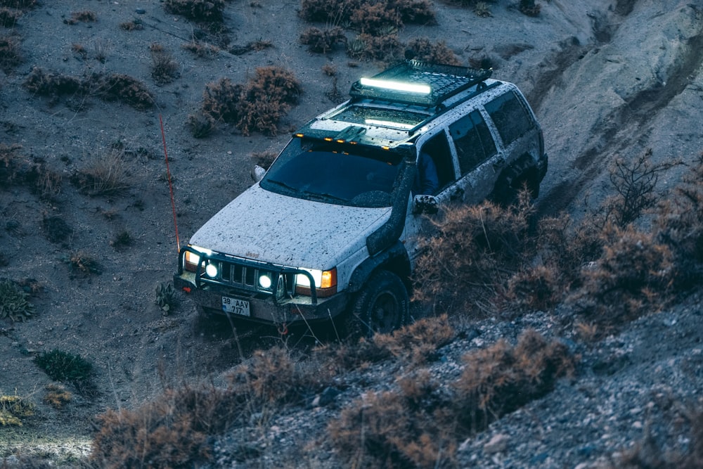 a white truck driving down a dirt road