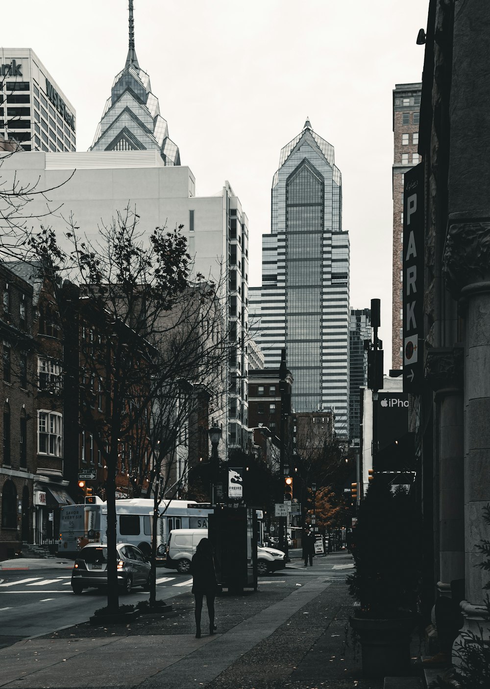 a man walking down a street next to tall buildings