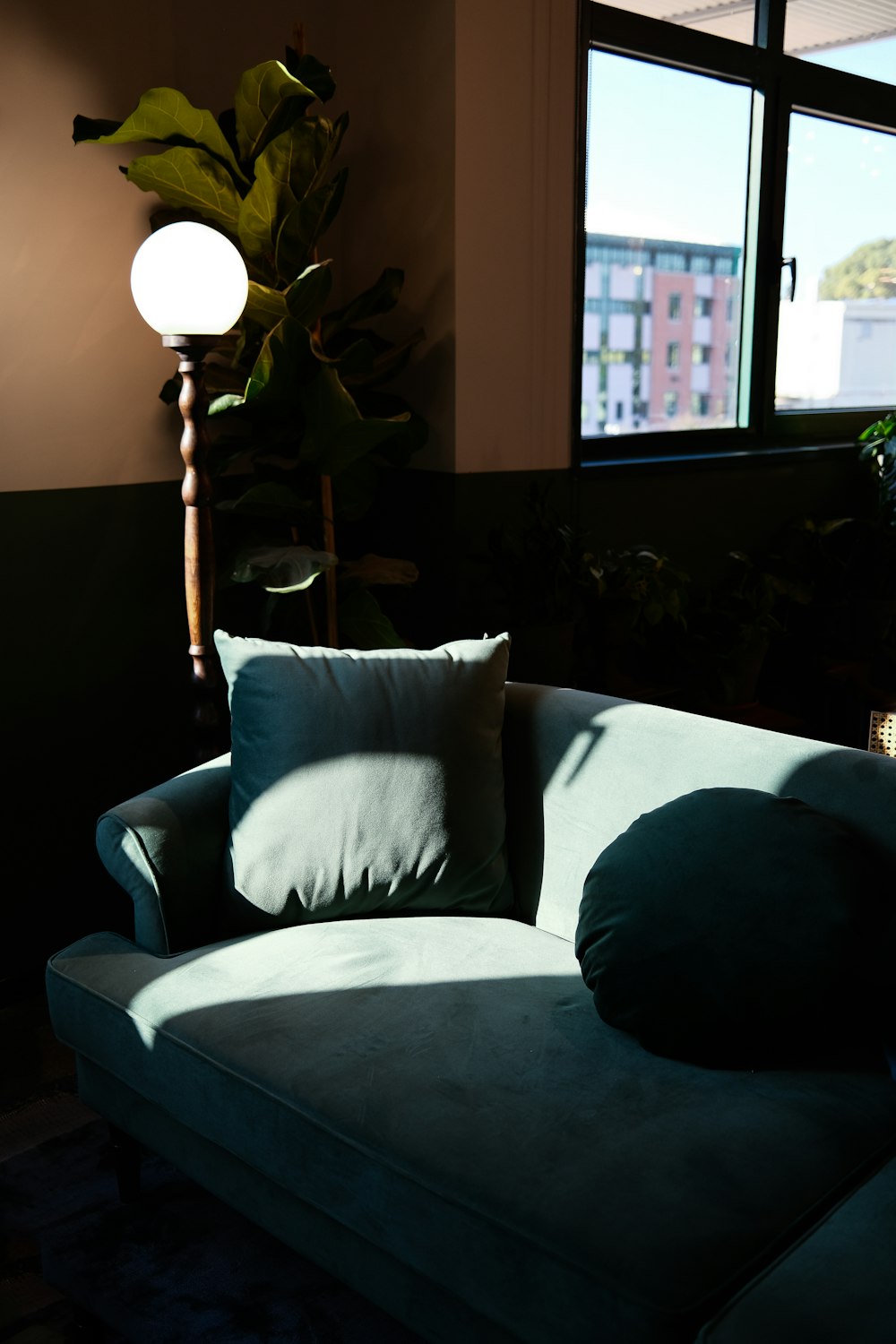 a couch with pillows and a lamp in a room