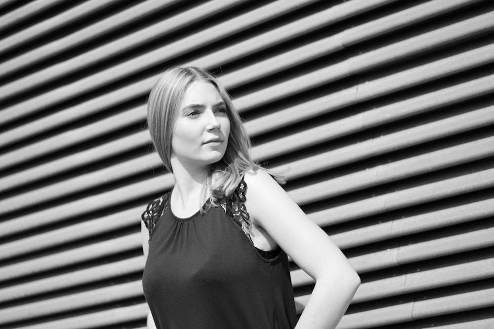 a woman standing in front of a wall with her hands on her hips