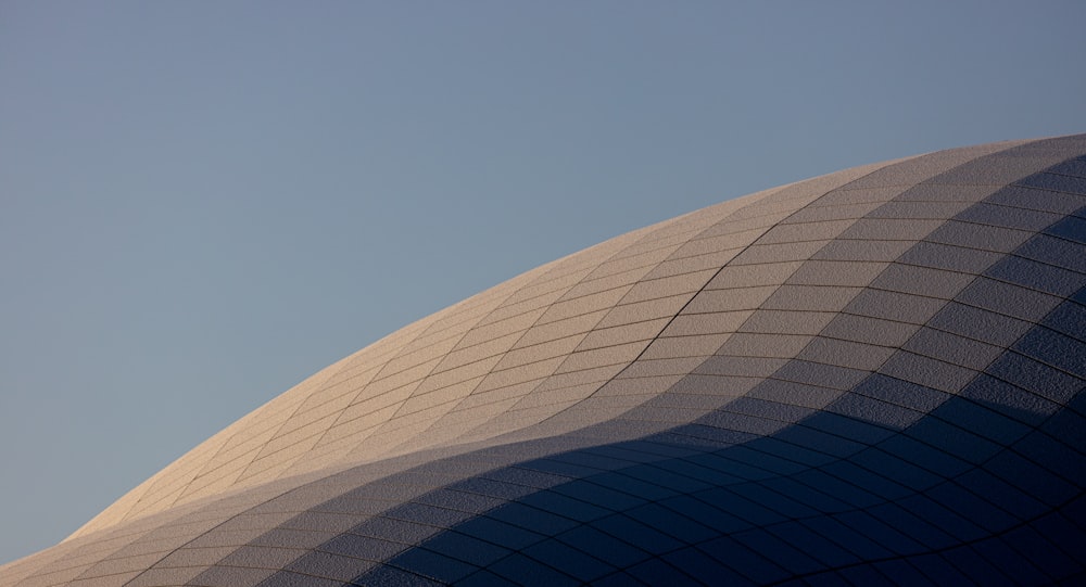 a large building with a plane flying in the sky