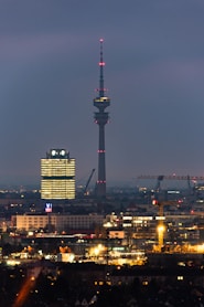 a view of a city at night with a very tall building in the background