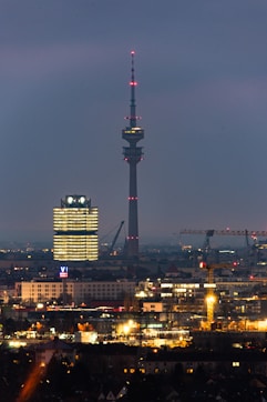 a view of a city at night with a very tall building in the background