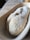 Close-up of hands shaping sourdough dough inside a rustic banneton basket dusted with flour.