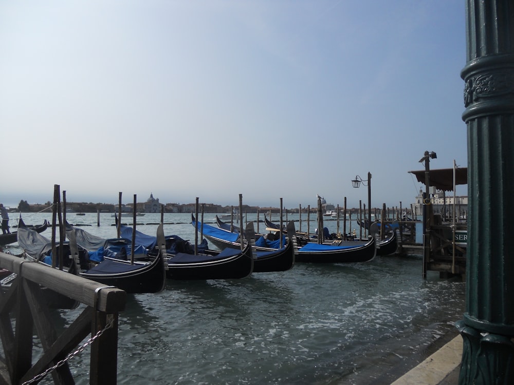 a row of gondolas sitting next to a pier
