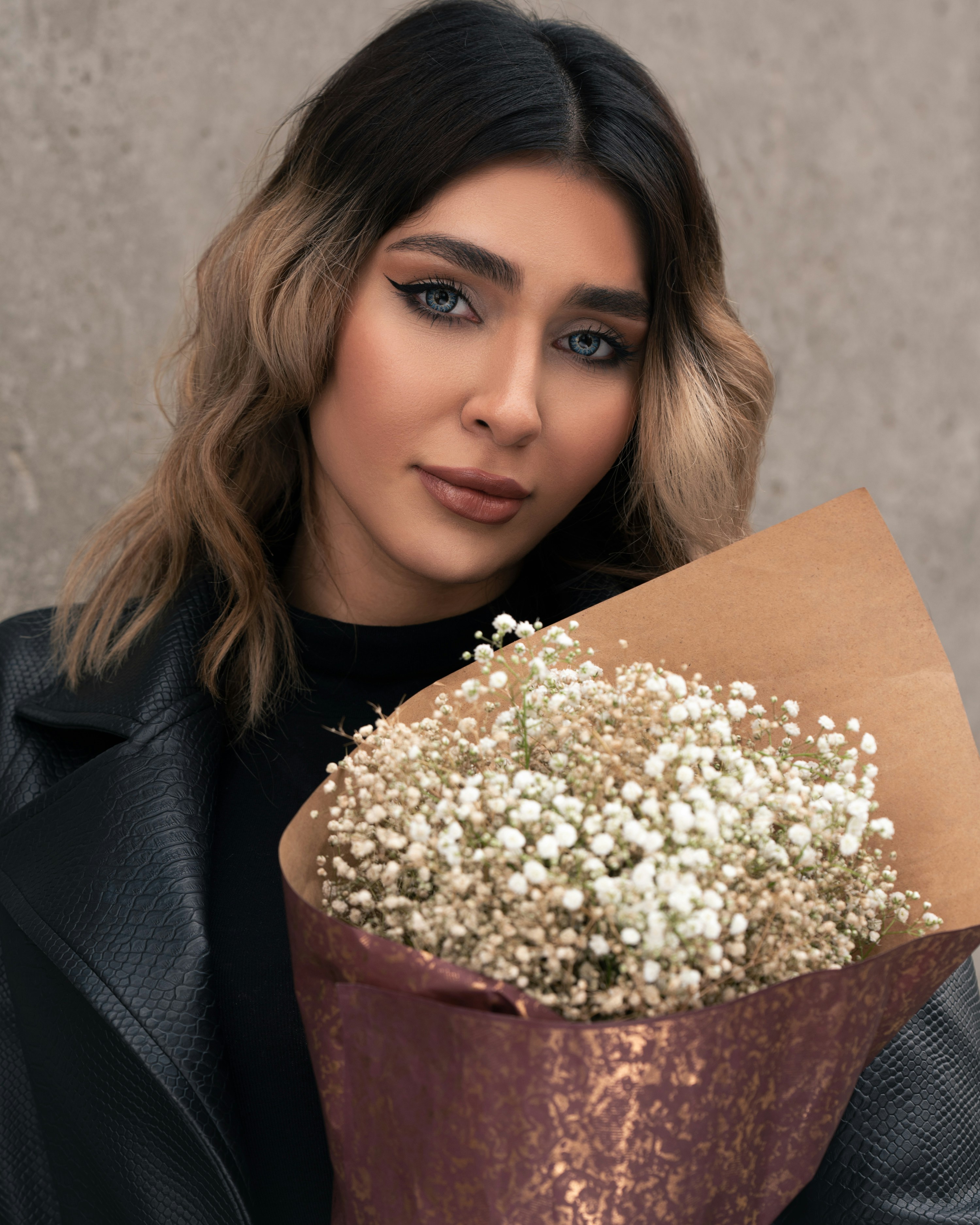 a woman is holding a bouquet of flowers