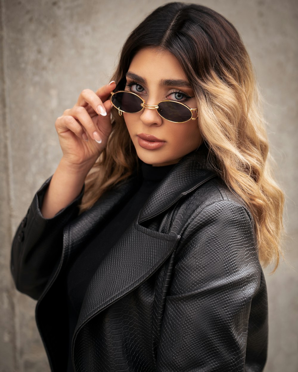 a woman wearing sunglasses and a black jacket