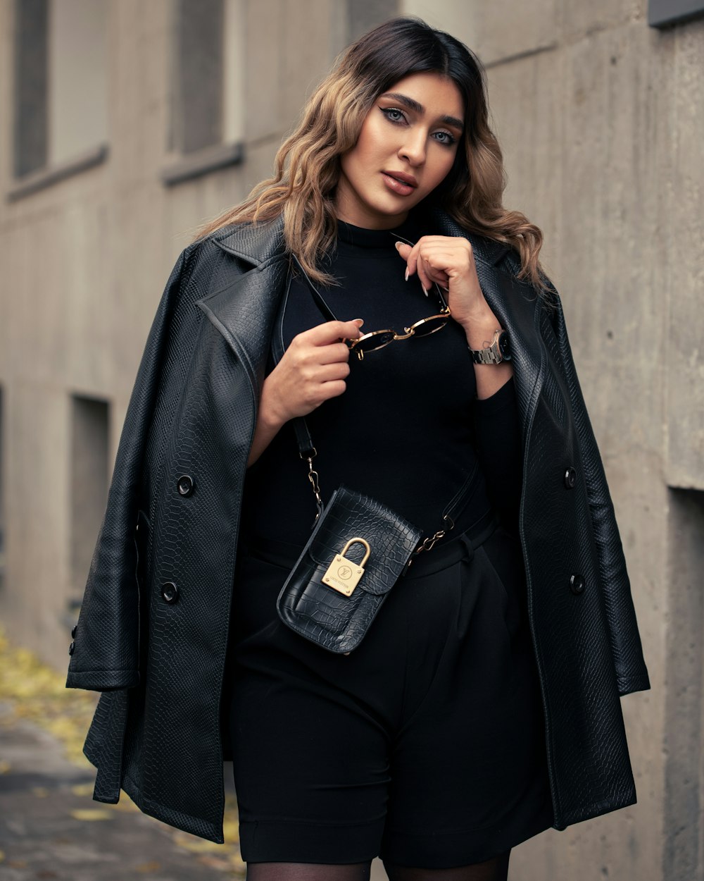 a woman wearing a black outfit and a black coat