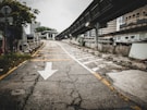 an empty street with a white arrow painted on it